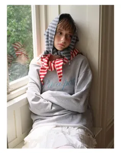 Détail d'un foulard triangle en laine rayé gris et d'une capuche avec tenue décontractée
