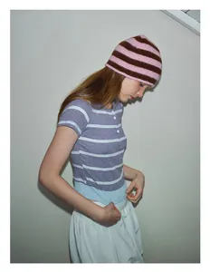Detail of pink and brown striped knit wool hat styled with a striped henley shirt