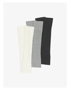 Nahaufnahme gestrickter Yoga-Stulpen in Weiß, Grau und Schwarz mit feinem Rippenmuster