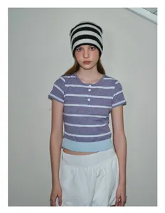 Detail of blue contrast hem on purple and white striped knit t-shirt with button neck