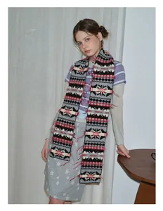 Detailed view of the vintage geometric jacquard pattern and fringes on the knit scarf