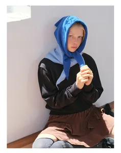 Detail of bright blue knitted hooded scarf paired with corduroy skirt in retro style