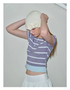 Detalle de gorro de punto blanco con flores de ganchillo 3D hechas a mano artesanalmente
