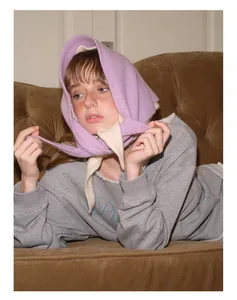 Détail d'une cagoule en tricot lilas mélange de laine avec des liens blanc crème
