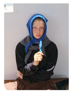 Detailed texture of 100% wool knit triangular scarf in bright blue on a casual model
