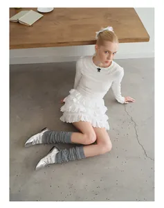 Detail of grey wool knit leg warmers paired with silver pointed lace-up ballet flats