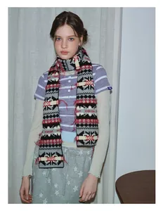 Detail of vintage Fair Isle knit scarf with geometric patterns and red feather tassels
