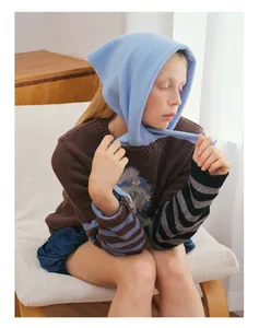 Detailed view of sky blue wool knitted drawstring hood and vintage embroidered sweater