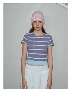 Detail of pink knitted wool beanie with decorative ruffled lace trim for autumn winter
