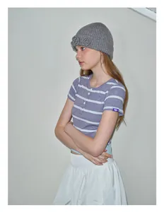Primer plano de un gorro de punto gris con detalle de flor de ganchillo artesanal