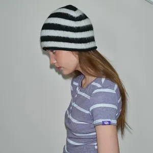 Woman wearing a striped wool knit beanie and matching short sleeve shirt in a casual style
