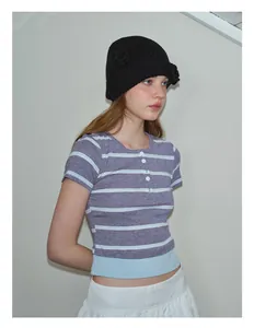 Detalle de top henley de punto a rayas con botones y dobladillo azul en contraste