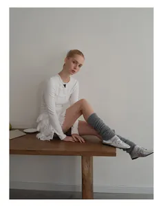 Detailed texture of white wool blend knit leg warmers paired with ballet flat shoes