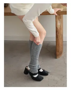 Primer plano de calentadores de lana gris con zapatos Mary Jane negros elegantes