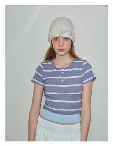 Close-up of cream knit beanie with scalloped ruffled edges and woolen texture detail