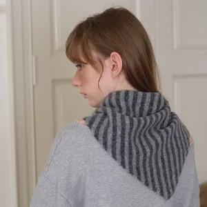 Écharpe rayée minimaliste en laine tricotée pour femme vue sous un angle latéral chic
