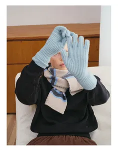 Detailed knit texture of light blue touchscreen wool gloves paired with a striped winter scarf