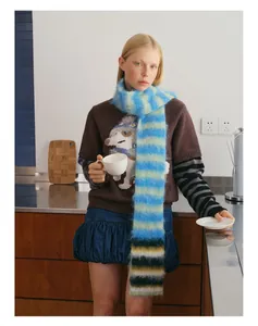 Detail van zachte gebreide sjaal met blauw-groene strepen voor retro winteroutfits