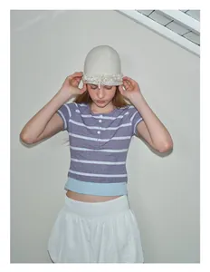 Close-up of creamy white wool blend knitted beanie with elegant ruffled edge detail