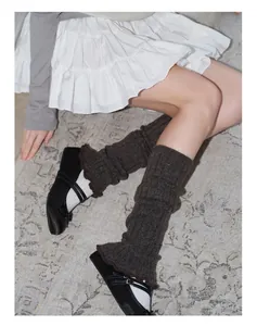 Close-up of brown wool blend knit leg warmers with lace edges and ribbed texture