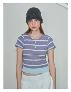 Close-up of a women's dark gray cable knit beanie paired with a striped henley top