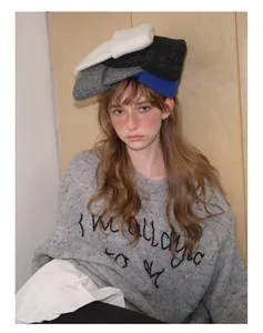 Detail of soft wool blend knit hats in multiple colors stacked on model's head