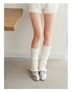 Close-up of cream wool blend ballet style knit leg warmers with textured ribbed patterns