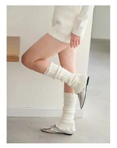 Detailed texture of white chunky knit leg warmers with cozy stacked y2k style effect