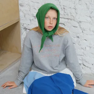 Gray embroidered crewneck sweatshirt paired with a green knitted hooded scarf for women