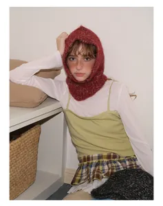 Dettaglio passamontagna rosso in misto lana abbinato a gonna scozzese vintage e gilet