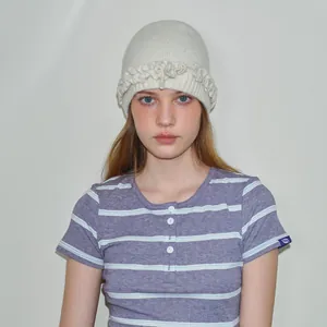 Chic beige wool knit beanie with ruffle details and feminine bow design for winter