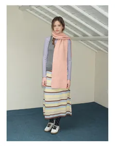 Vue complète de l'écharpe en laine rose avec gilet gris et jupe midi rayée en tricot