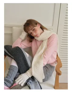 Detailed texture of chunky cable knit wool blend scarf in cream white winter style