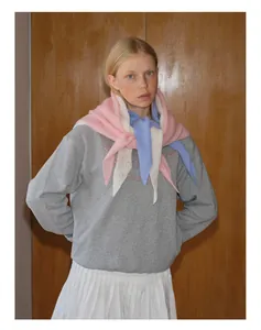 Détail de foulards en maille ajourée en laine superposés en rose, blanc et bleu