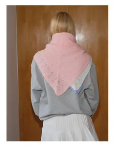 Écharpe triangulaire en laine rose avec motif ajouré détaillé sur le dos d'un modèle