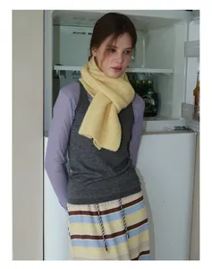 Detail shot of bright yellow knitted wool scarf styled with colorful knitwear