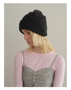 Detail of soft dark grey knit beanie showing high-quality wool texture on a female model