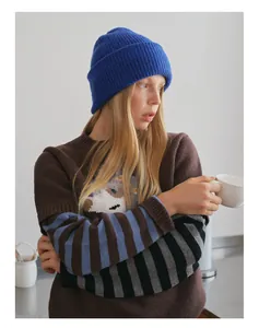 Detail of creative knit sweater featuring cartoon patterns and striped patchwork sleeves