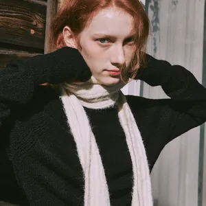 Chic cream wool blend cable knit scarf with black sweater in an elegant autumn setting