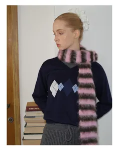 Detail van roze en bruin gestreepte mohair sjaal met een ruitjes gebreide trui