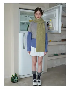 Close-up of green wool knit scarf paired with a retro outfit and Mary Jane shoes