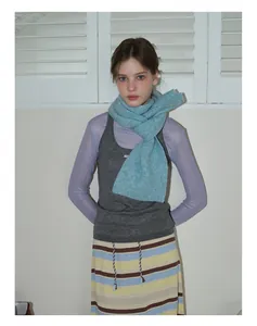 Détail d'une écharpe en tricot bleu clair 35% laine montrant une texture douce et velue