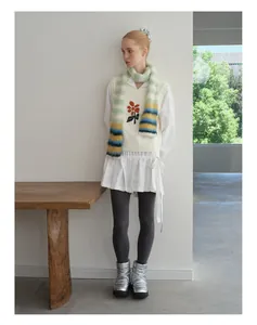 Detail van een zachte veelkleurige gestreepte gebreide sjaal met een wit vest en shirt