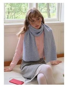 Detailed knit texture of light blue wool blend scarf paired with pink cardigan