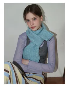 Détail d'une écharpe en maille bleu clair mélangée laine avec texture duveteuse sur mannequin