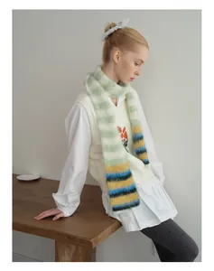 Detail van de kleurrijke gestreepte mohair sjaal en het witte gebreide bloemvest