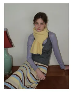 Détail d'une écharpe en maille jaune vif montrant la texture moelleuse et le style doux