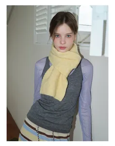 Gros plan d'une écharpe en maille jaune clair avec texture mohair sur un mannequin femme
