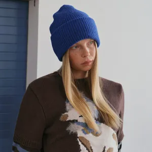 Classic navy blue ribbed alpaca wool knit beanie paired with a brown graphic sweater