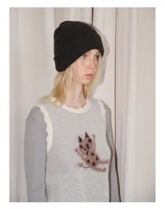 Detail of dark grey yak wool blend beanie paired with a cat pattern knit vest